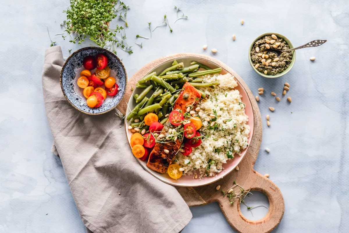 A plated meal with ceramic bowls and a wooden board on a linen cloth
